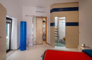 オートラントにあるDimora Corte del Seminarioのベッドルーム1室(赤いベッド1台、ガラスドア付)