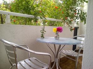 a table and chairs with a vase of flowers on it at Thalassa Studios in Faliraki