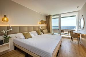 a bedroom with a large bed with a view of the ocean at Hotel Histrion in Portorož