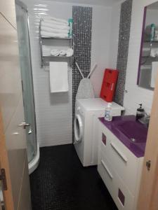 een badkamer met een wasmachine en een paarse wastafel bij BenalBeach Yasmine in Benalmádena