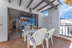 a white dining room with a table and chairs at Apartamentos las Lilas in Puerto del Carmen