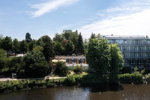 a building next to a body of water at Seminaris Hotel Potsdam Griebnitzsee in Potsdam