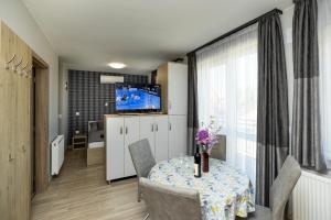 une salle à manger avec une table, des chaises et une télévision dans l'établissement Star Apartman, à Eger