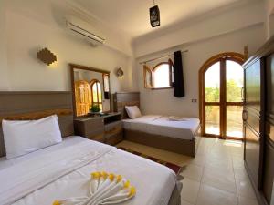 a bedroom with two beds and two windows at Villa 22 in Dahab
