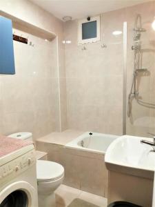 a bathroom with a toilet and a tub and a sink at Joan Apartment Gandia in Gandía