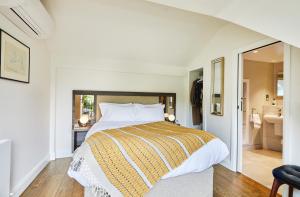 a bedroom with a large bed and a bathroom at José Pizarro The Swan Inn in Esher