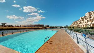 una piscina accanto a una spiaggia e alcuni edifici di Casa Las Islas - A Murcia Holiday Rentals Property a Roldán