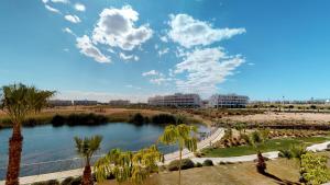 Blick auf einen Fluss mit Palmen und Gebäuden in der Unterkunft Casa Las Islas - A Murcia Holiday Rentals Property in Las Pedreñas