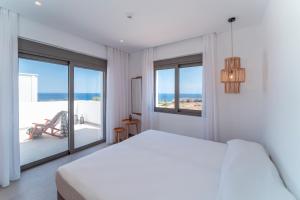 biała sypialnia z łóżkiem i dużym oknem w obiekcie Terra d'Oro Sea view villa with private pool w mieście Kiotari +23 zdjęcia