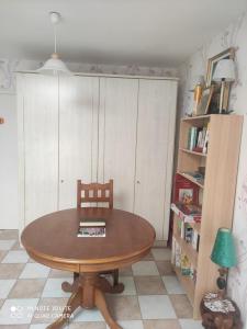 einen Esstisch mit einem Stuhl und einem Bücherregal in der Unterkunft POIRSON THIERY in Hagécourt