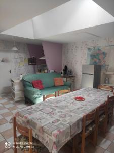 ein Wohnzimmer mit einem Tisch und einem grünen Sofa in der Unterkunft POIRSON THIERY in Hagécourt