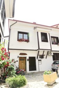a white house with flowers in the window at Eke Irin Apartments in Ohrid