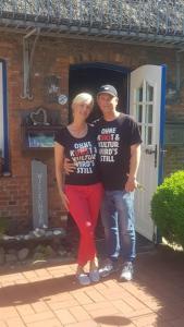 un homme et une femme debout devant une maison dans l'établissement Danners Landhaus, à Oevenum