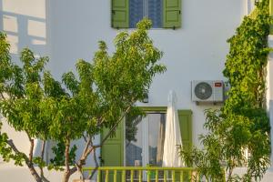 una casa con una puerta verde y una sombrilla en Zeras Apartments, en Adamas
