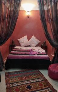 Schlafzimmer mit einem Bett mit roten Wänden und Vorhängen in der Unterkunft Riad Ahlsouss in Marrakesch