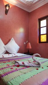 Un dormitorio con una cama con una serpiente de juguete. en Riad Ahlsouss, en Marrakech