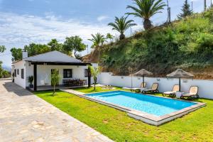 a backyard with a swimming pool and a house at Kanmarala in Alhaurín de la Torre