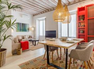 ein Wohnzimmer mit einem Tisch, Stühlen und einem Sofa in der Unterkunft San Mateo I in Madrid
