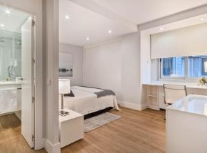 a white bedroom with a bed and a sink at Centro Colon I in Madrid