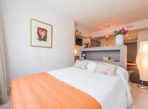 1 dormitorio con cama blanca y manta naranja en Villanueva III, en Madrid