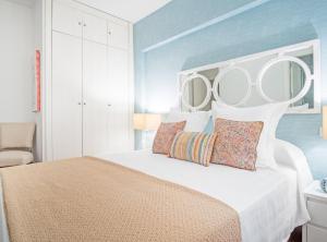 een slaapkamer met een groot bed met twee spiegels erboven bij Retiro VI in Madrid