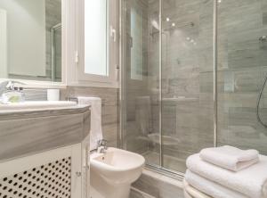 een badkamer met een douche, een toilet en een wastafel bij Retiro VI in Madrid