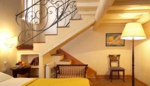 皮耶特拉倫加的住宿－羅坎達德爾博爾戈酒店，一间卧室设有楼梯、一张床和一张桌子