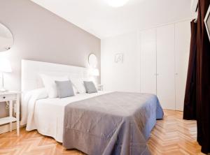 een witte slaapkamer met een groot bed in een kamer bij Princesa V in Madrid