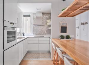 a kitchen with white cabinets and a wooden counter top at CASTELLO IV in Madrid
