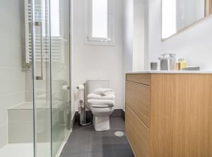 een badkamer met een toilet en een glazen douche bij Claudio Coello I in Madrid
