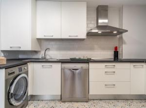 a kitchen with white cabinets and a washing machine at Alberto Aguilera I in Madrid