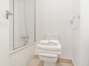 uma casa de banho com um chuveiro e um WC com toalhas em Alonso Martinez I em Madrid