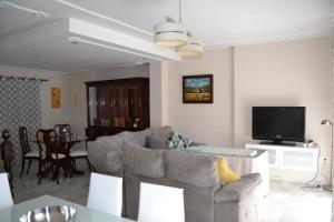 een woonkamer met een bank en een tv bij Torre de Arena y Playa in Sanlúcar de Barrameda