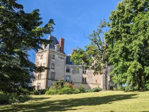 ein altes Schloss auf einem grasbewachsenen Feld mit Bäumen in der Unterkunft Château de Saint Bonnet les Oules in Saint-Bonnet-les-Oules