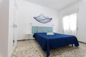 a bedroom with a blue bed in a white room at Puntamare in Peschici