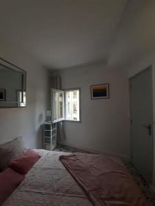 een slaapkamer met een bed en een raam bij Studio de l'Horloge - Studio de Charme, hyper centre Maison Jean Vilar in Avignon