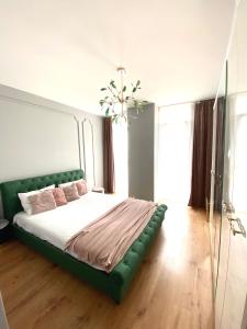 a bedroom with a large bed with a green headboard at Velvet Home in Timişoara