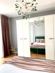 a bedroom with a bed and a large mirror at Velvet Home in Timişoara