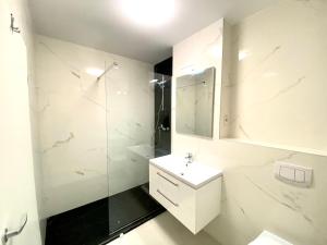 a white bathroom with a sink and a shower at Velvet Home in Timişoara +13 photos