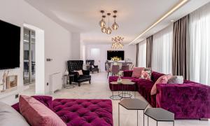 uma sala de estar com sofás roxos e uma sala de jantar em Palace Residence em Kaštela