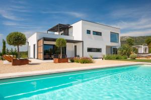 una casa con piscina di fronte a una casa di Villa Promissa Terra a Dubrava