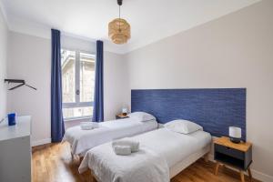 two beds in a room with a blue wall at Le Reef - Pépite dans l'Intramuros in Saint Malo