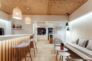 a kitchen and living room with a bar and chairs at Mari Hotel & Maisonettes in Tolo