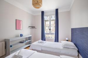 a bedroom with two beds and a window at Le Reef - Pépite dans l'Intramuros in Saint Malo