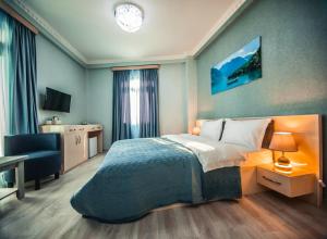 een slaapkamer met een bed, een bureau en een stoel bij MUSMORE Boutique Hotel in Tbilisi City