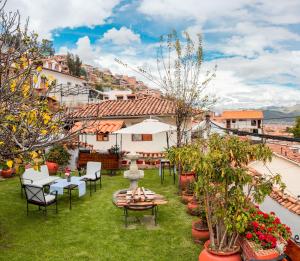 a patio with chairs and tables and potted plants at Hotel Encantada Casa Boutique Spa in Cusco