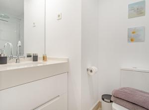 a white bathroom with a sink and a mirror at ALONSO MARTINEZ II in Madrid