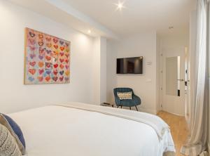 a bedroom with a white bed and a painting on the wall at ALONSO MARTINEZ II in Madrid