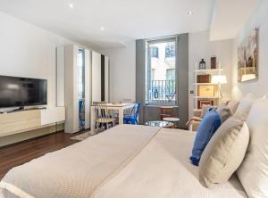 een slaapkamer met een groot bed en een woonkamer bij Cibeles I in Madrid
