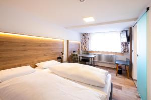 sypialnia z dużym białym łóżkiem i biurkiem w obiekcie Gasthof Kreuz w mieście Vöhrenbach